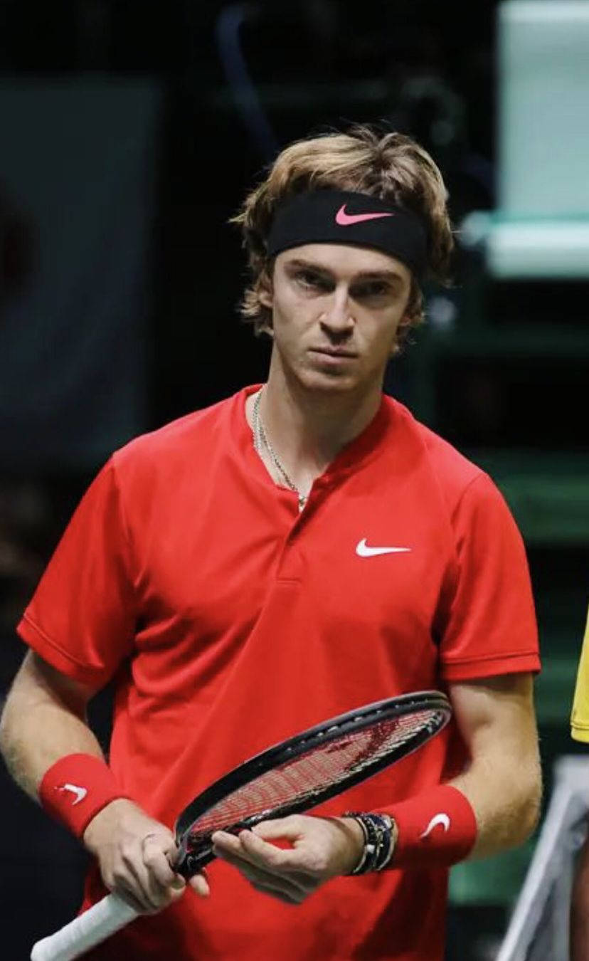 World-renowned Tennis Player, Andrey Rublev Holding A Tennis Racket Background