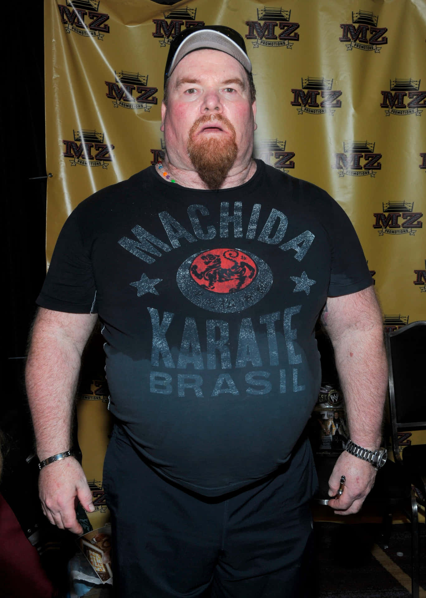 Wrestling Legend Jim Neidhart Posing With Yellow Tarpaulin Background
