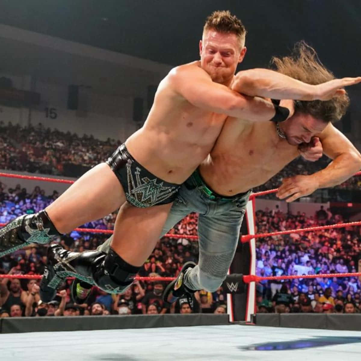 Wrestling Pro John Morrison In Action Against The Miz Background
