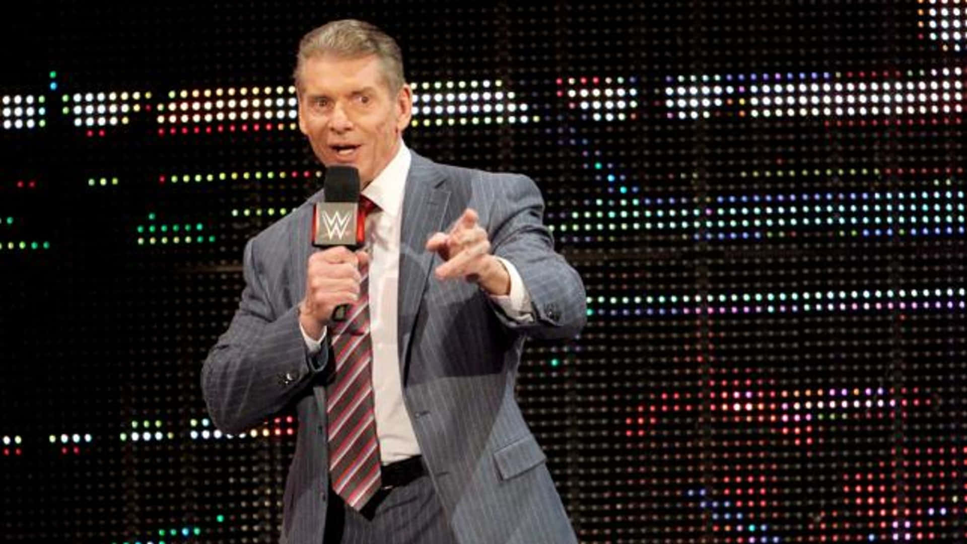 Wwe Commentator Vince Mcmahon Holding A Mic Background