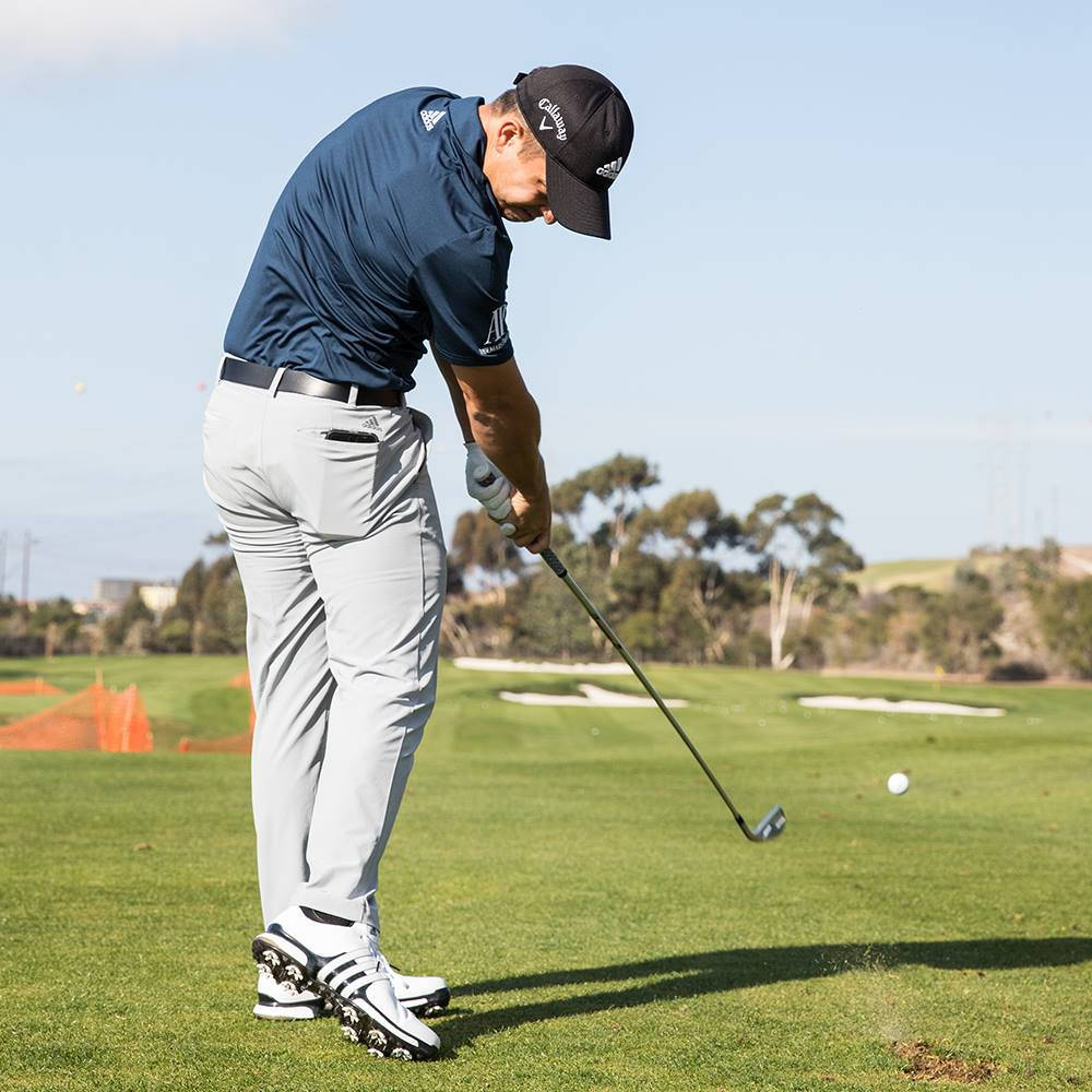 Xander Schauffele Hitting A Golf Ball Background