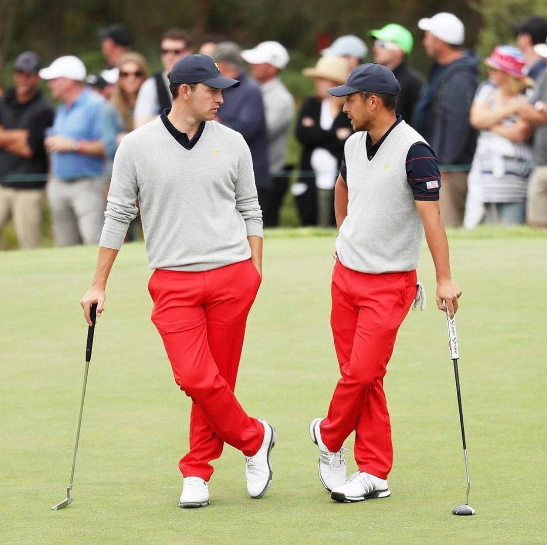 Xander Schauffele Talking To Golfer Background