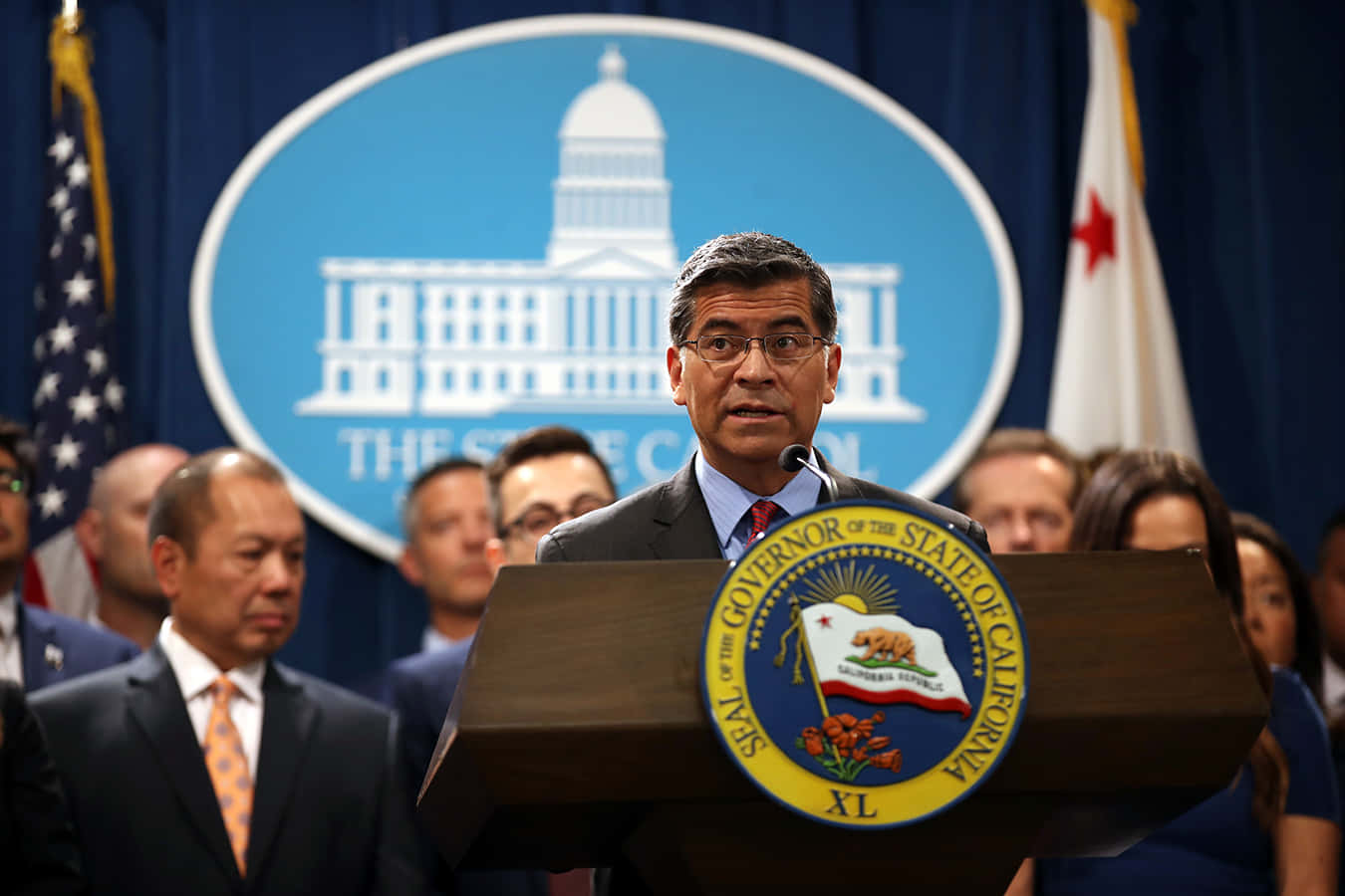 Xavier Becerra Behind The Podium Background