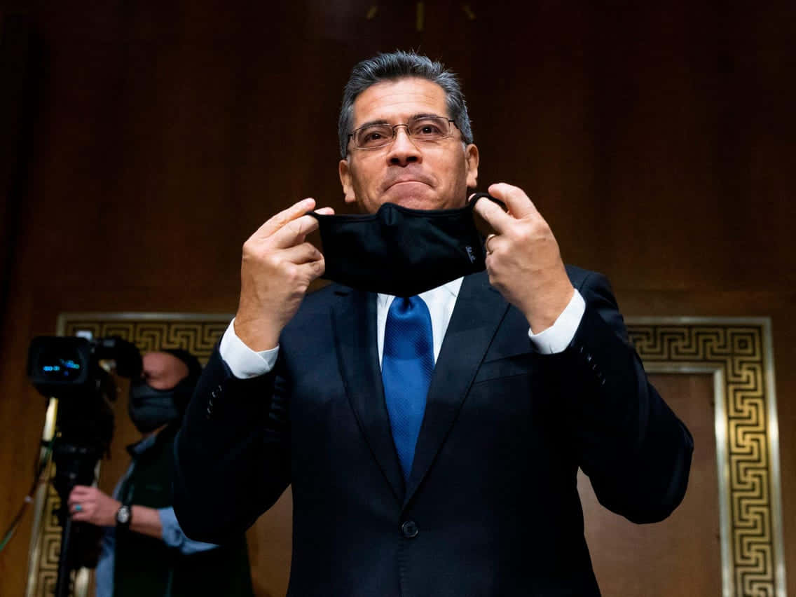 Xavier Becerra Removing His Mask Background