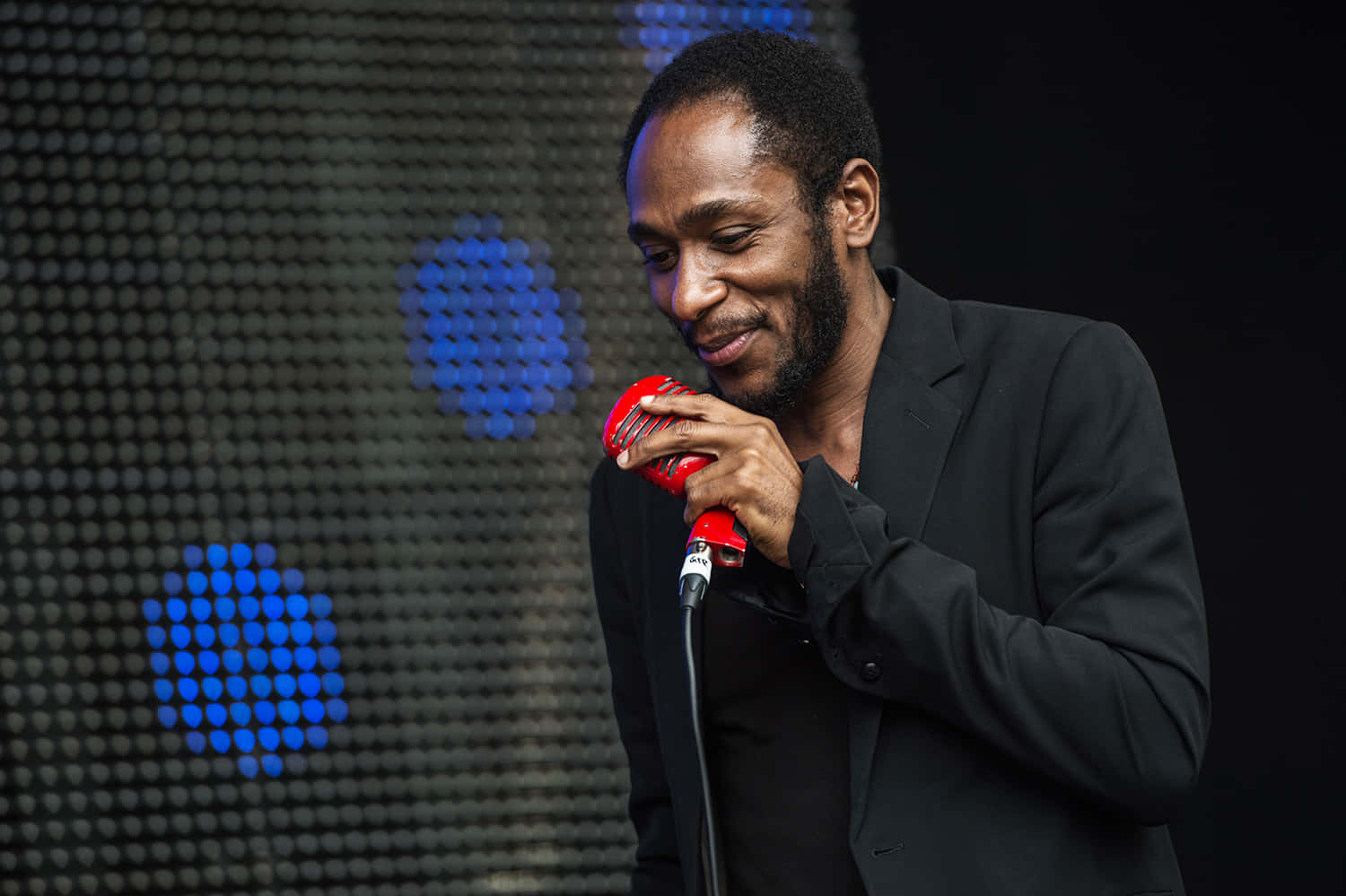 Yasiin Bey Performing At An International Stage Background