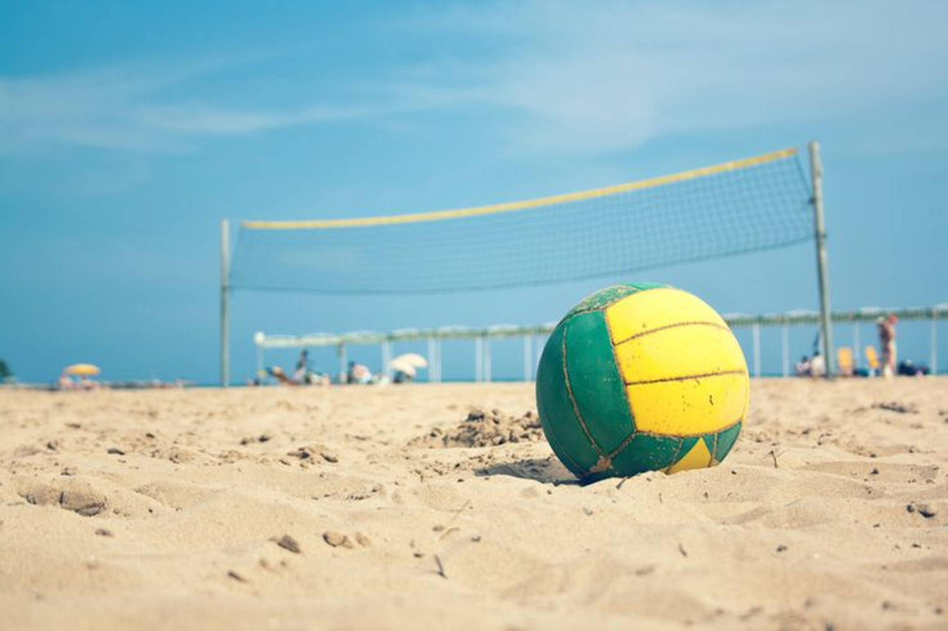 Yellow And Green Beach Volleyball On Sand Background