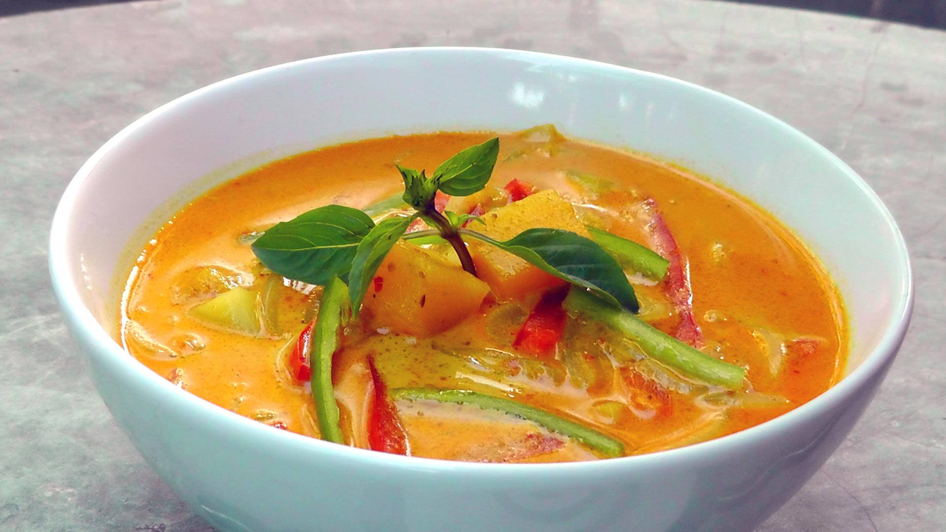 Yellow Curry Topped With Basil Herbs And Chili Background