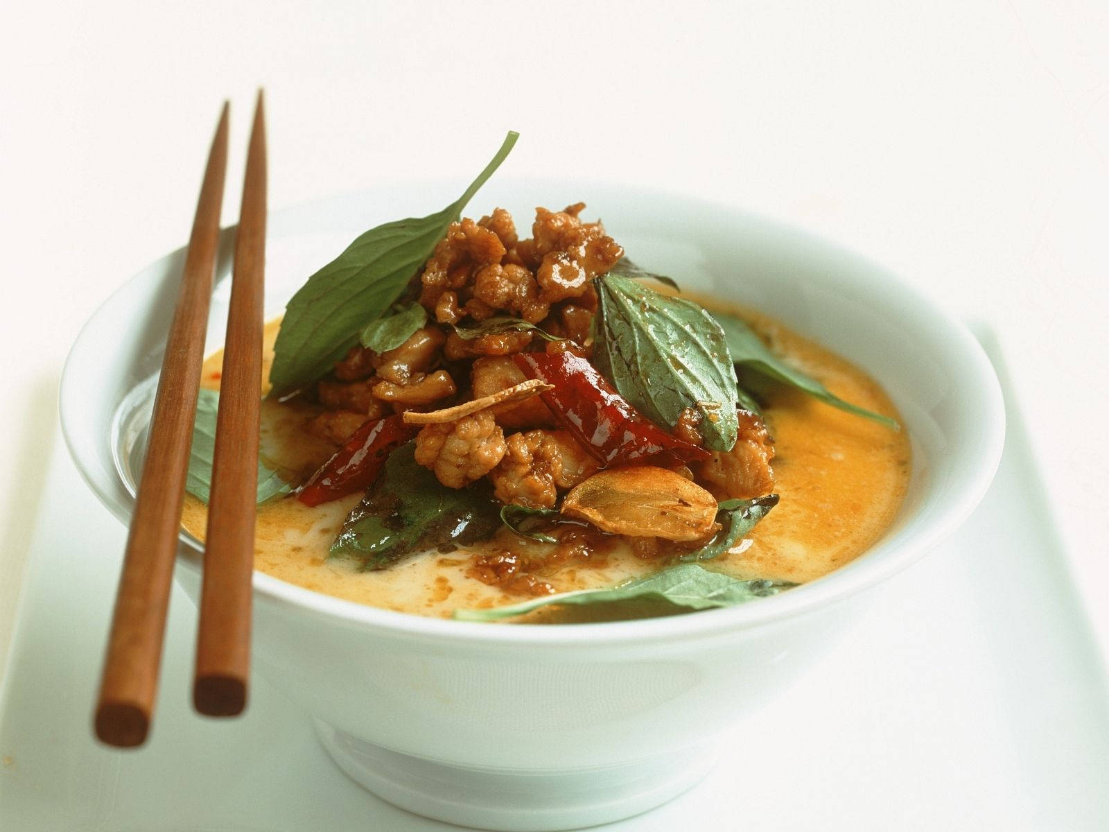 Yellow Curry Topped With Basil Leaves And Red Chili