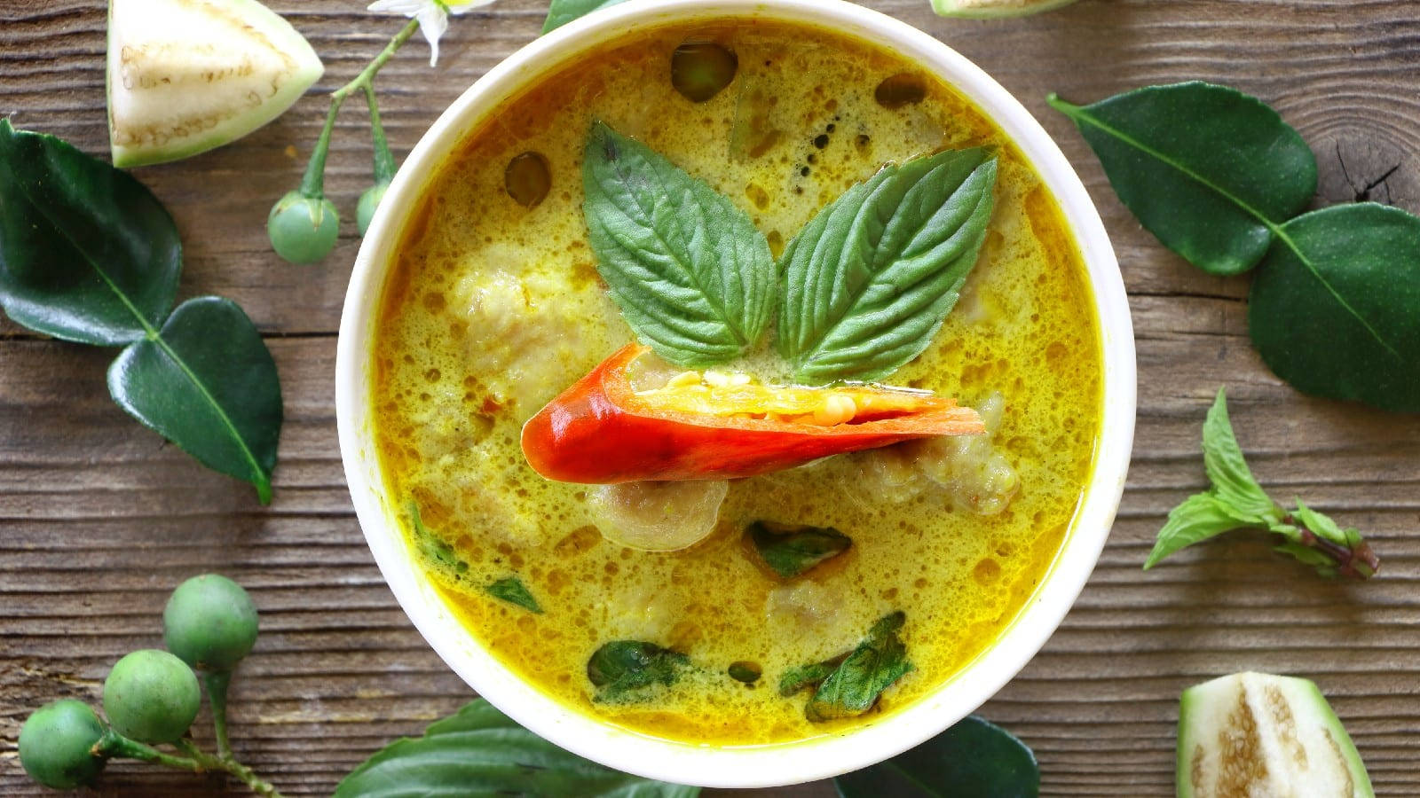 Yellow Curry With Basil Leaves And Red Chili Background