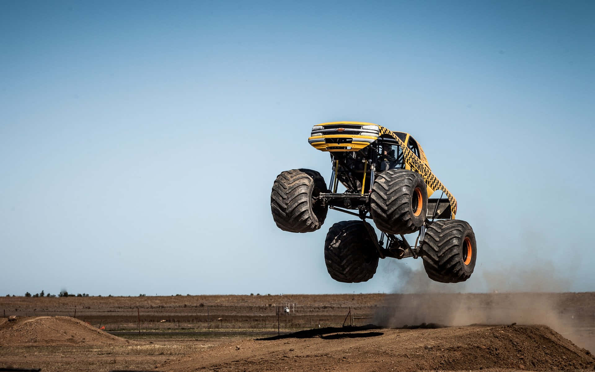 Yellow Monster Truck Going Upwards Background