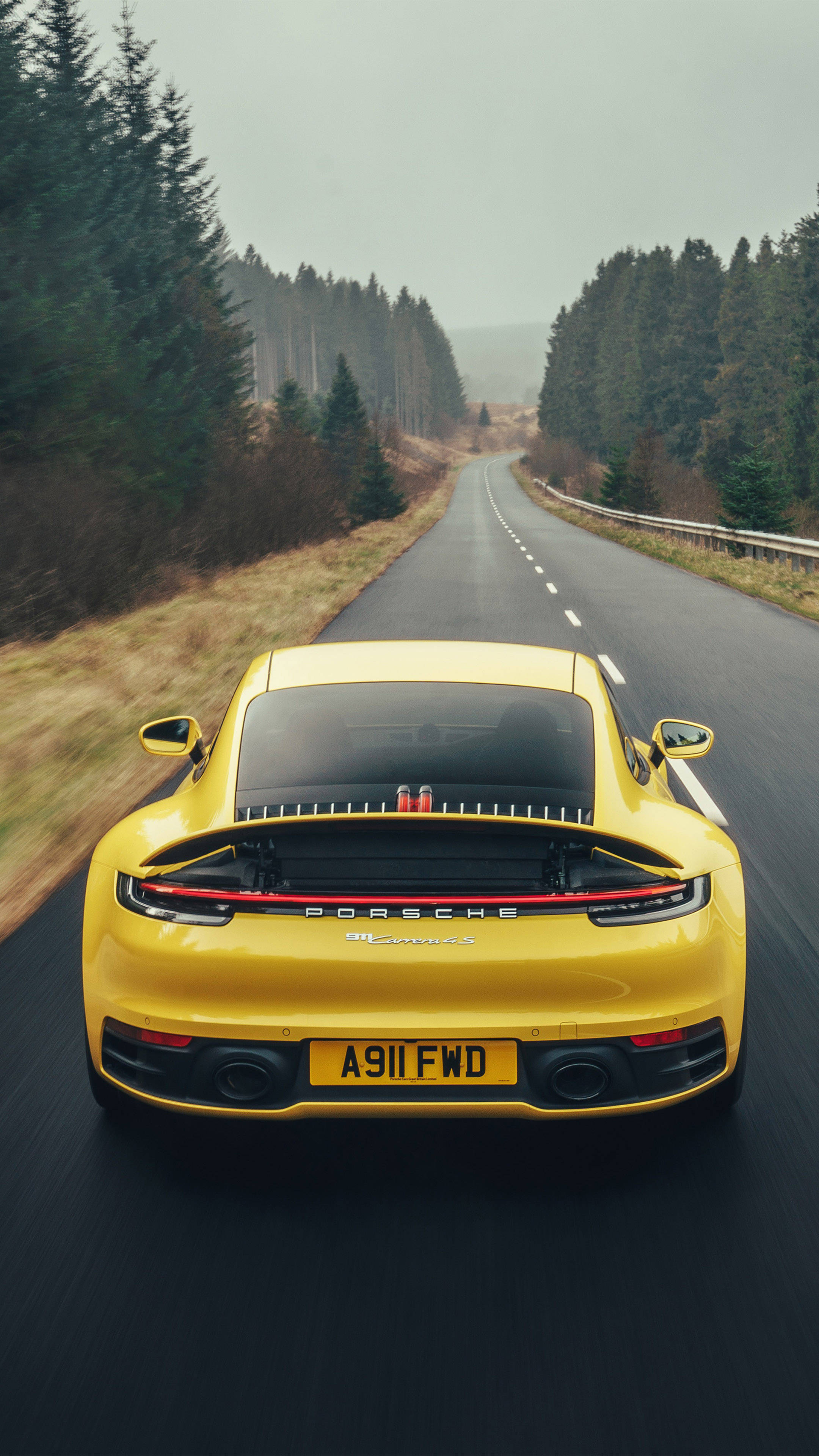 Yellow Porsche 911 Surrounded By Trees Background