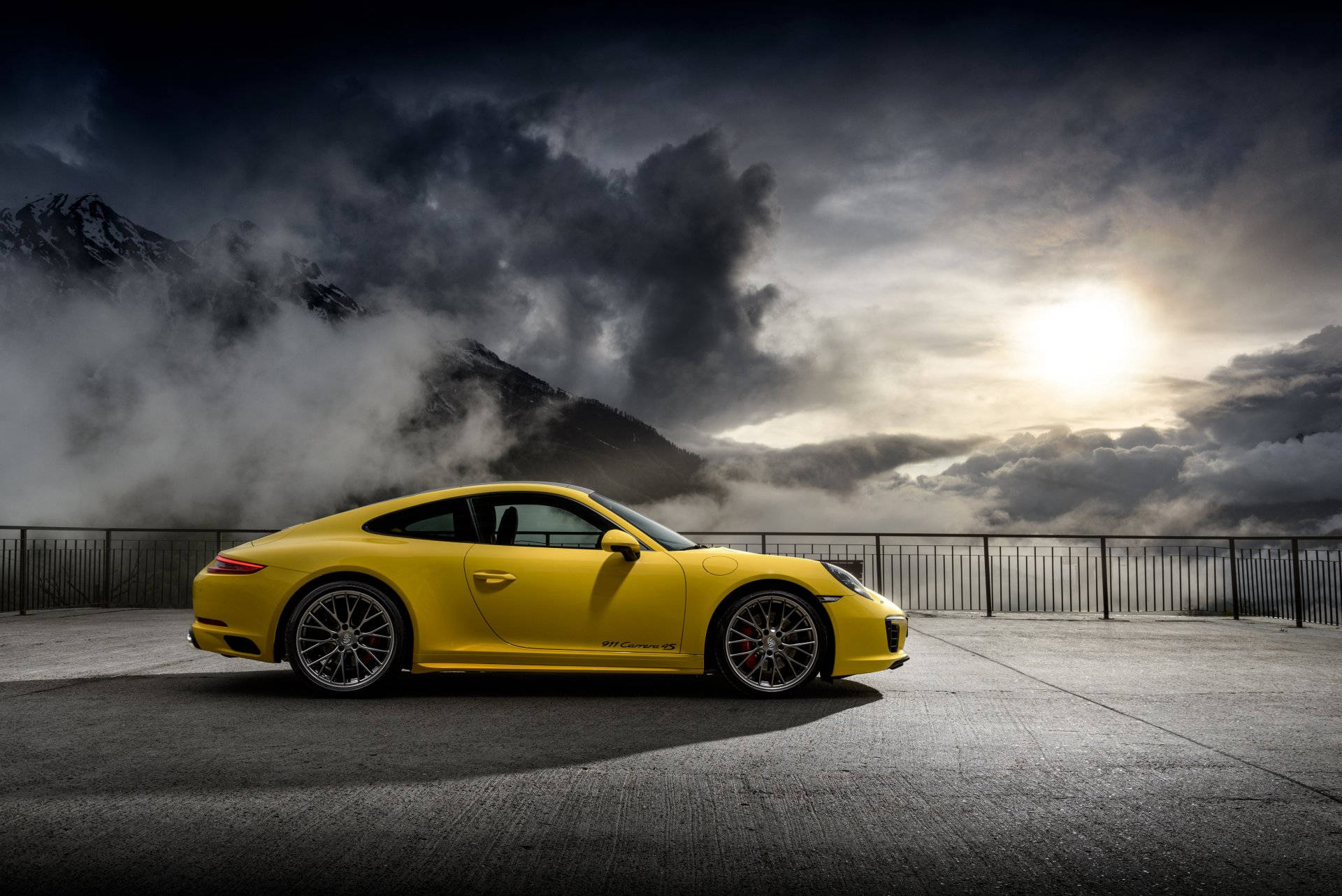 Yellow Porsche 911 Under Cloudy Sky Background