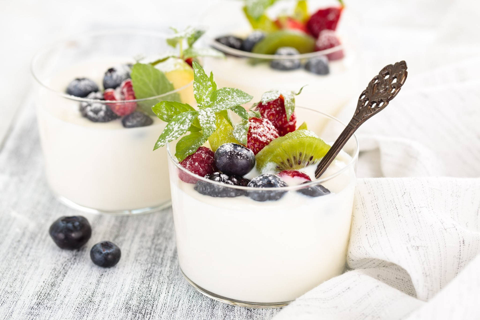 Yogurt With Fruits And Mint Leaves Background