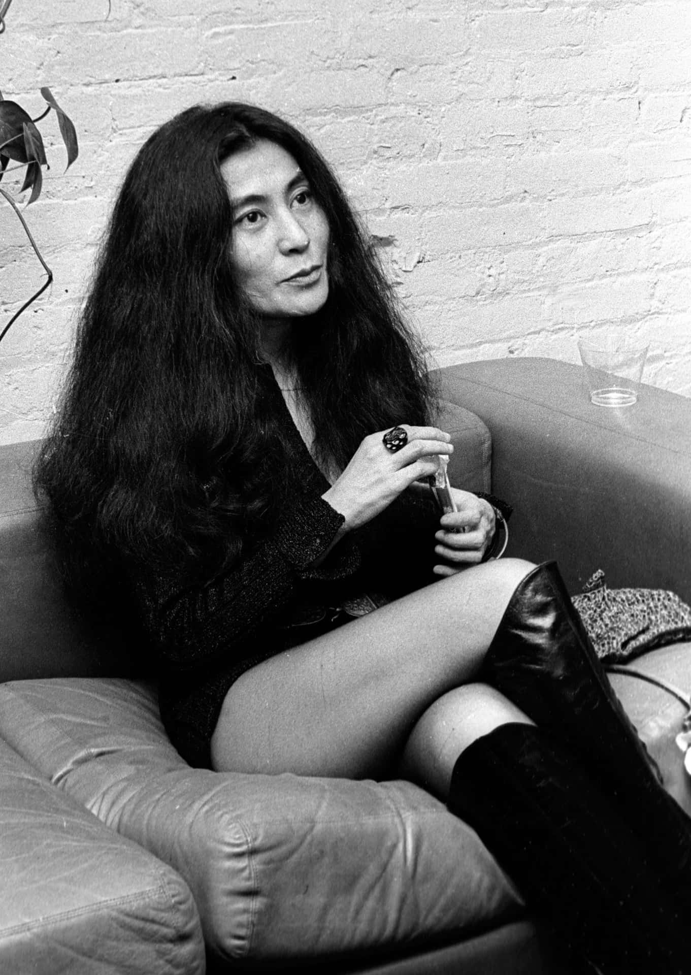 Yoko Ono Sitting On Sofa Background