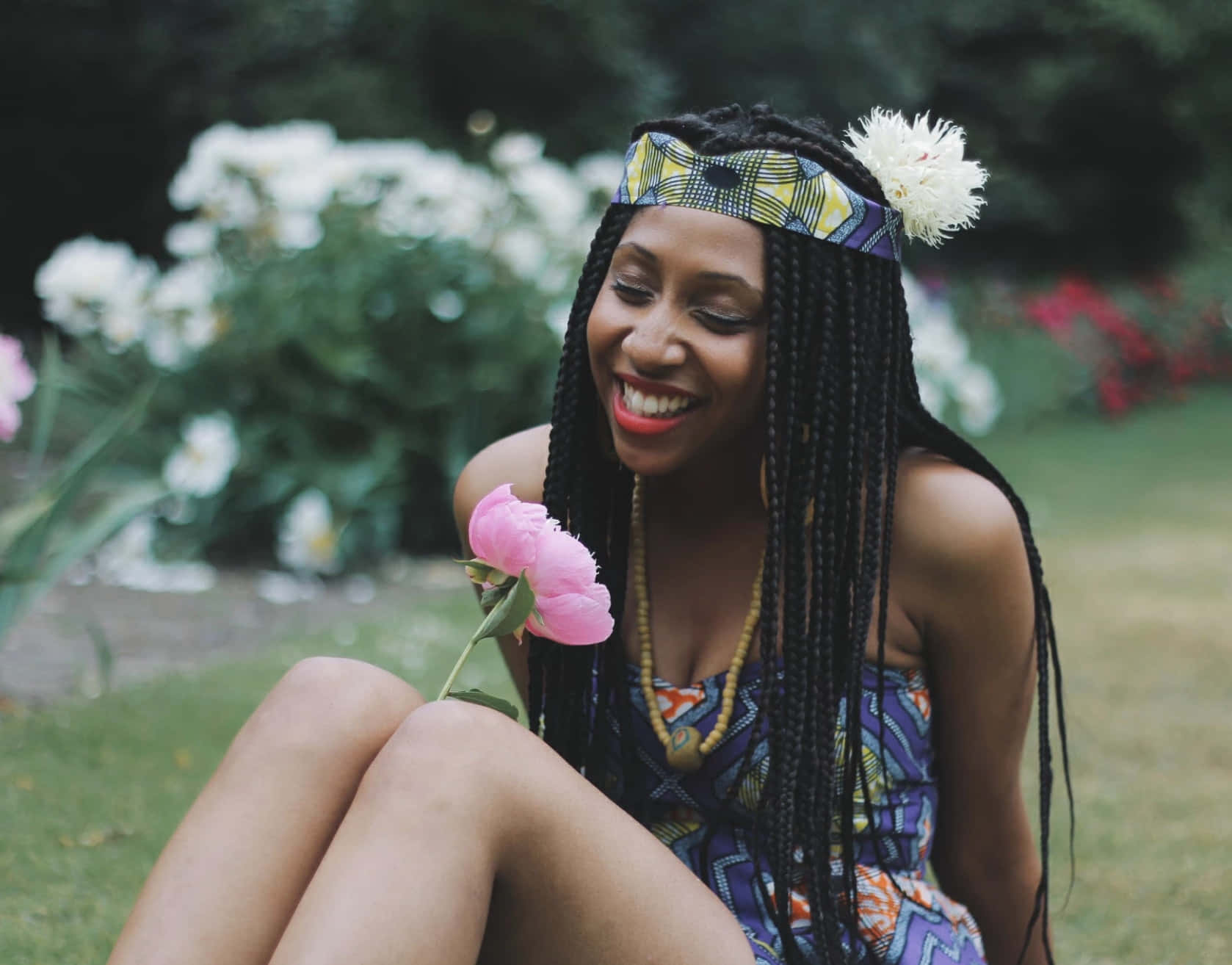 Young Black Woman Smelling A Flower Background