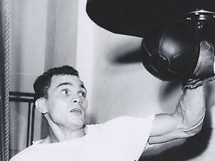 Young Carlos Ortiz Hitting Speed Bag Background