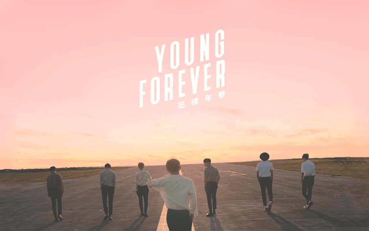 Young Forever - A Group Of People Standing On An Airport Runway Background