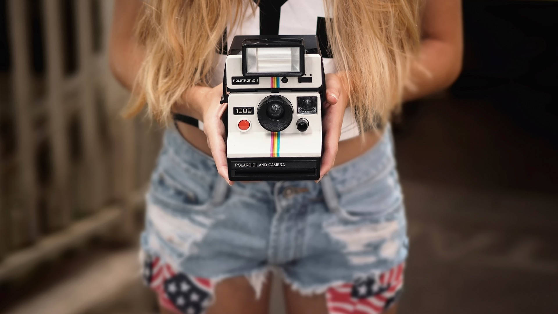 Young Girl Capturing Memories With Classic Polaroid Camera Background