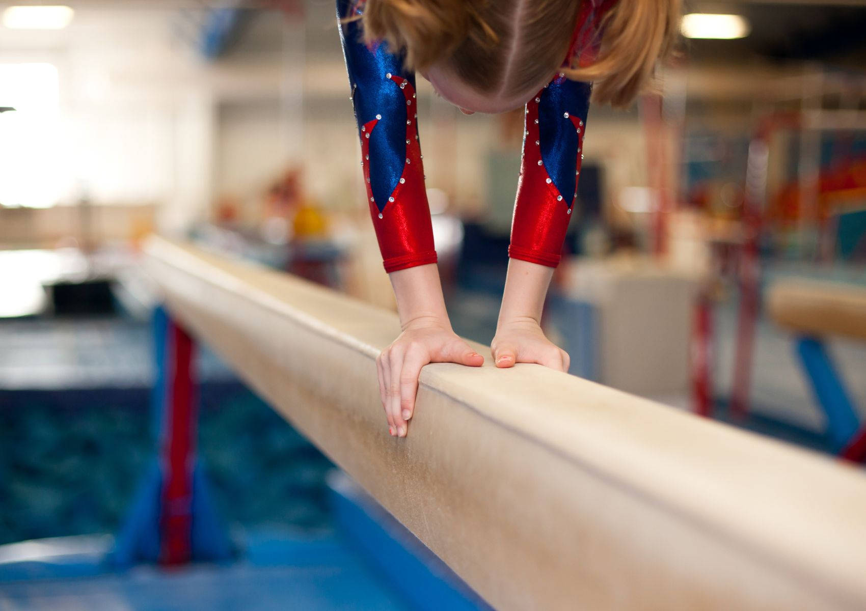 Young Gymnast Doing Handstand On Balance Beam Background