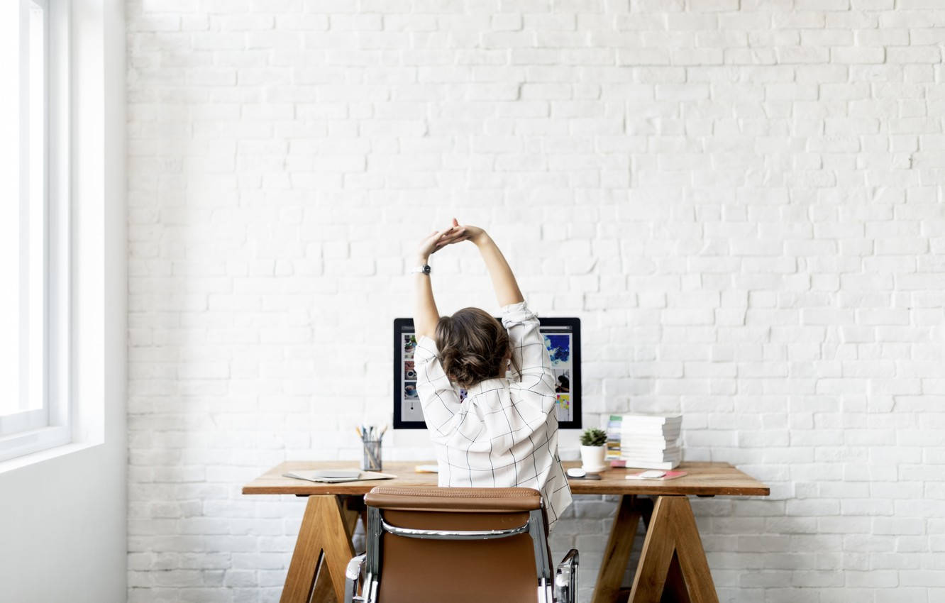 Young Professional Woman Stretching At Her Workplace