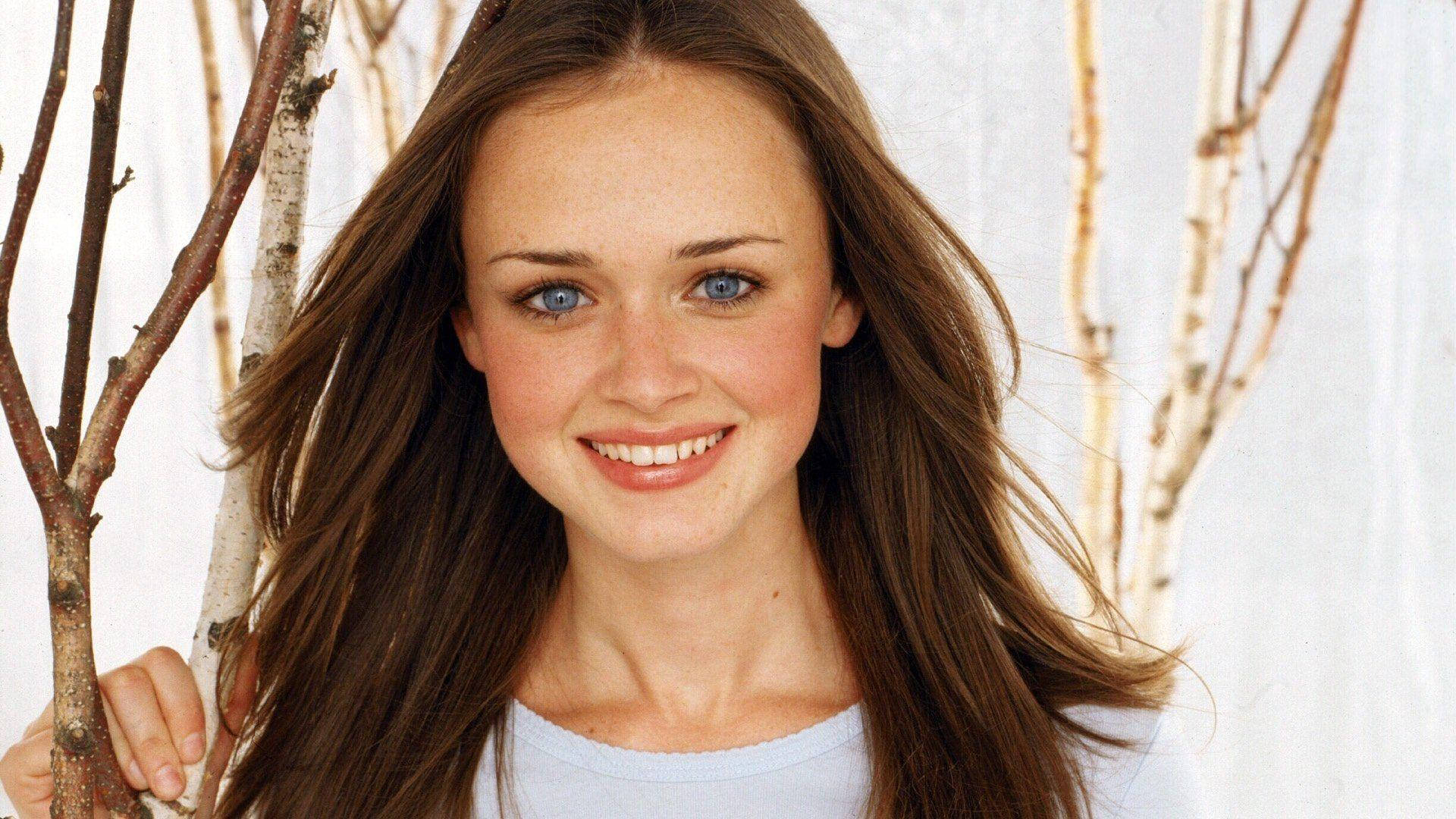 Young Rory Gilmore Smiling In Stars Hollow Background