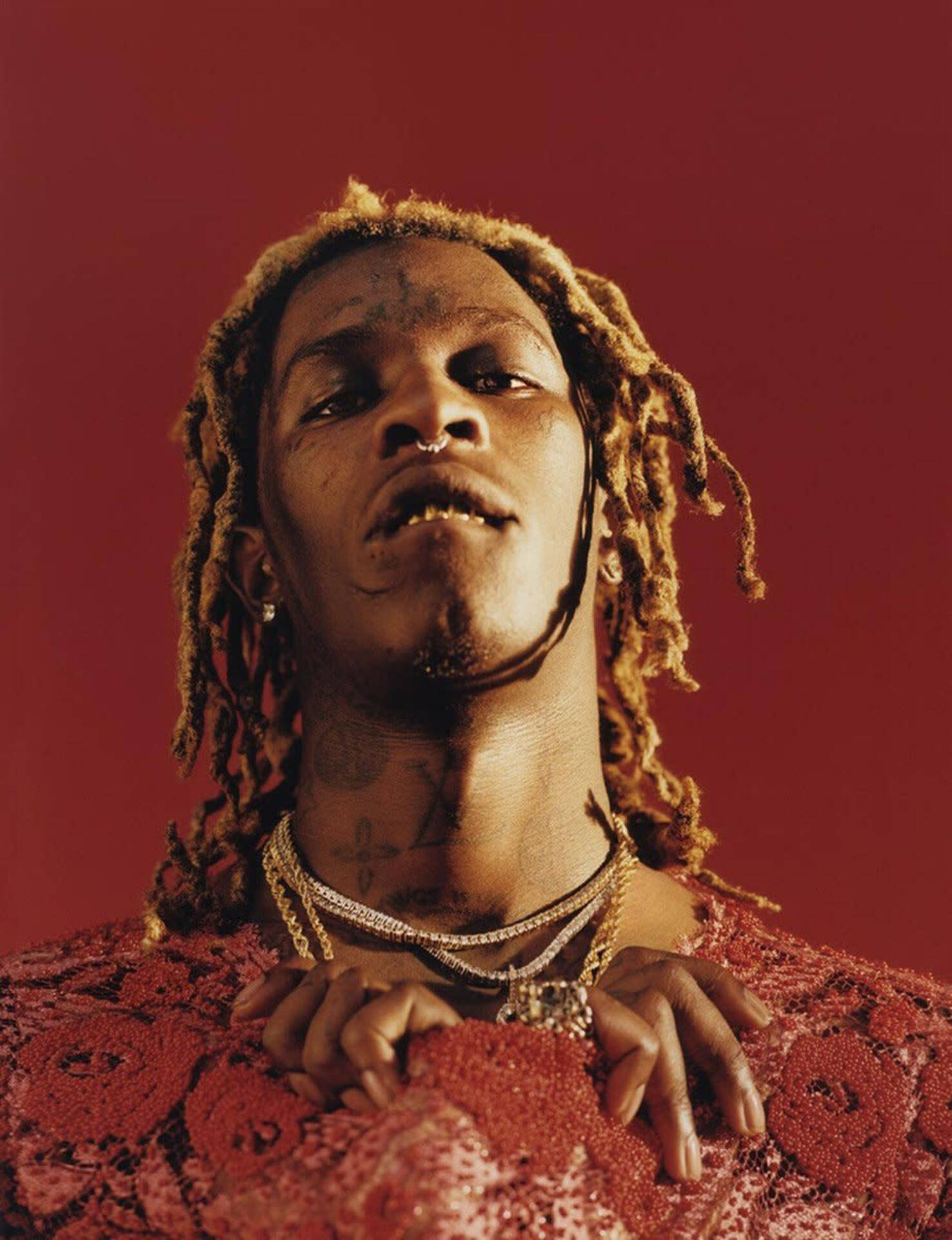 Young Thug Posing By A Red Phone Background