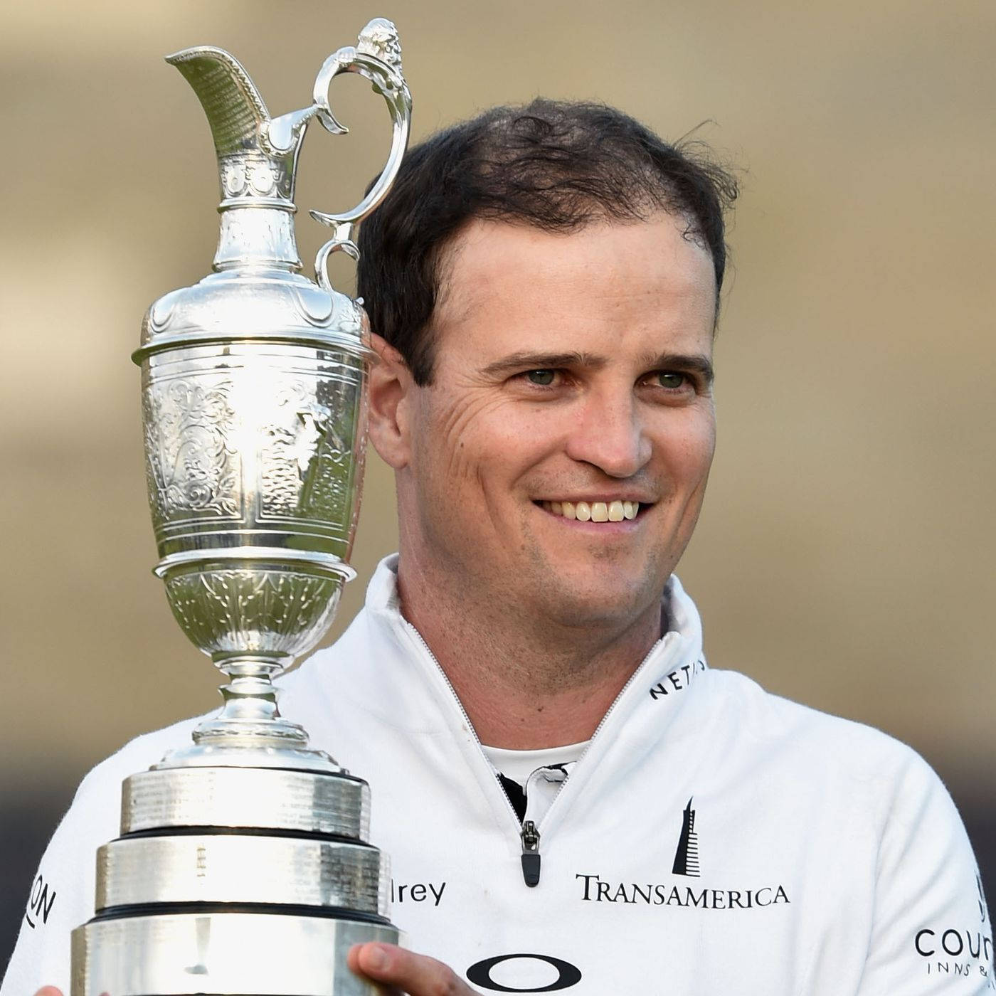 Zach Johnson Holding A Trophy Background