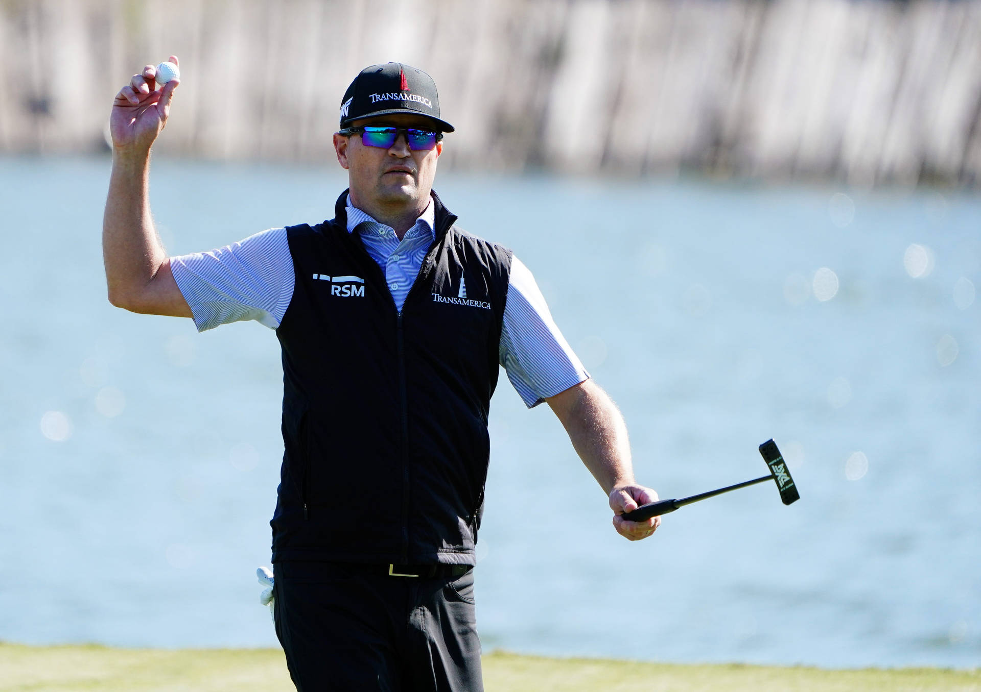 Zach Johnson Near A Lake Background