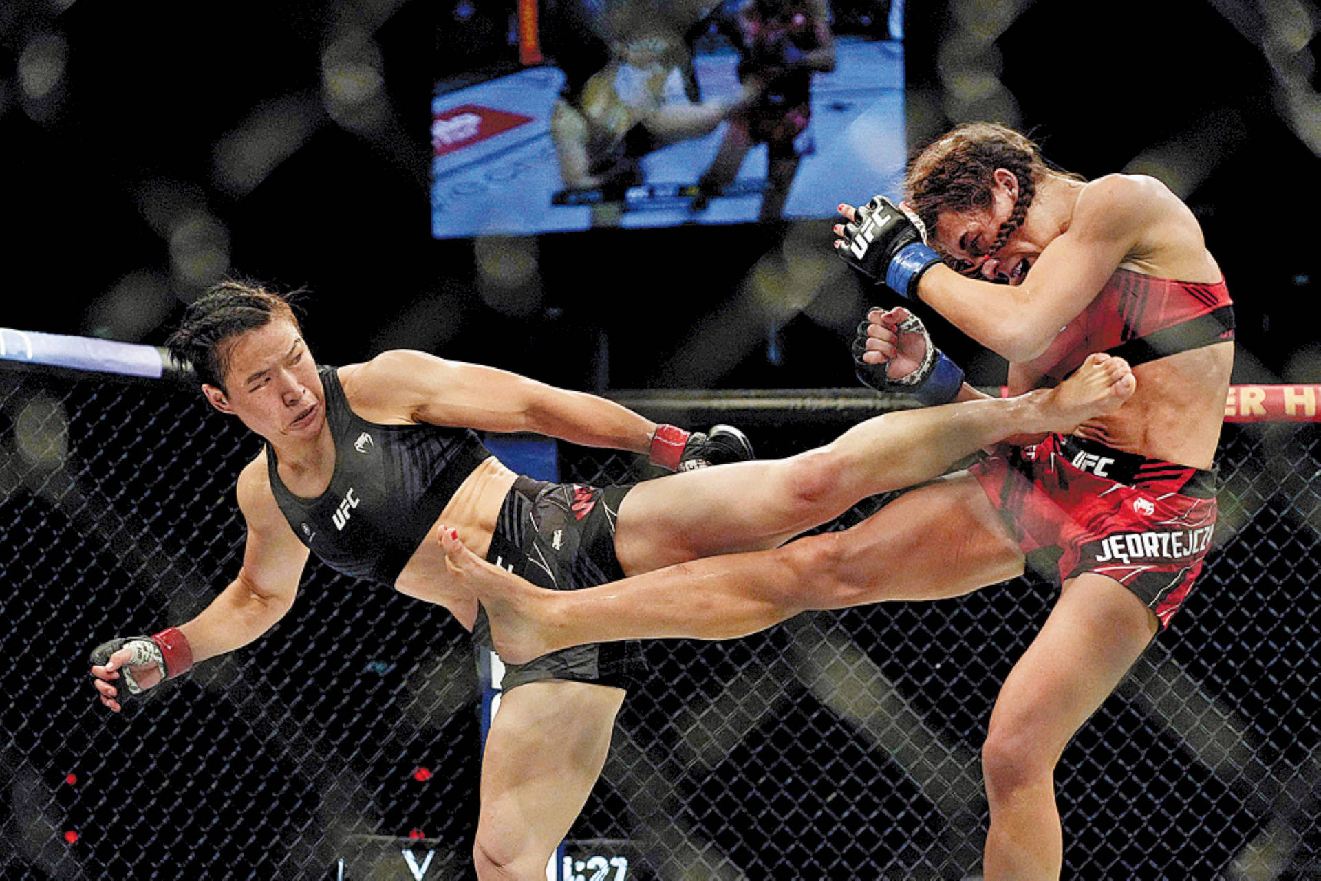 Zhang Weili Fiercely Kicks Joanna Jedrzejczyk In The Ring Background