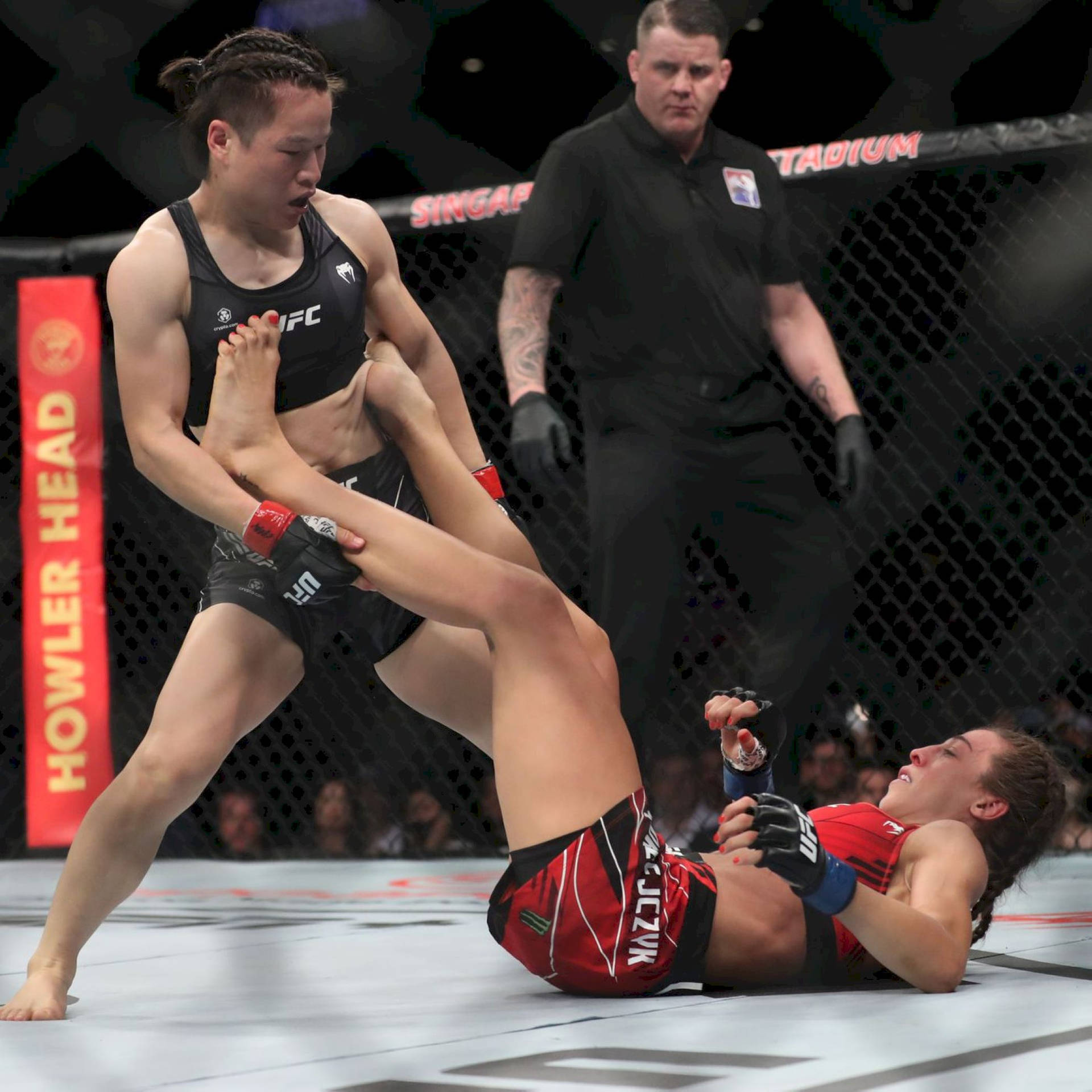 Zhang Weili Holding Joanna Jędrzejczyk Feet Background