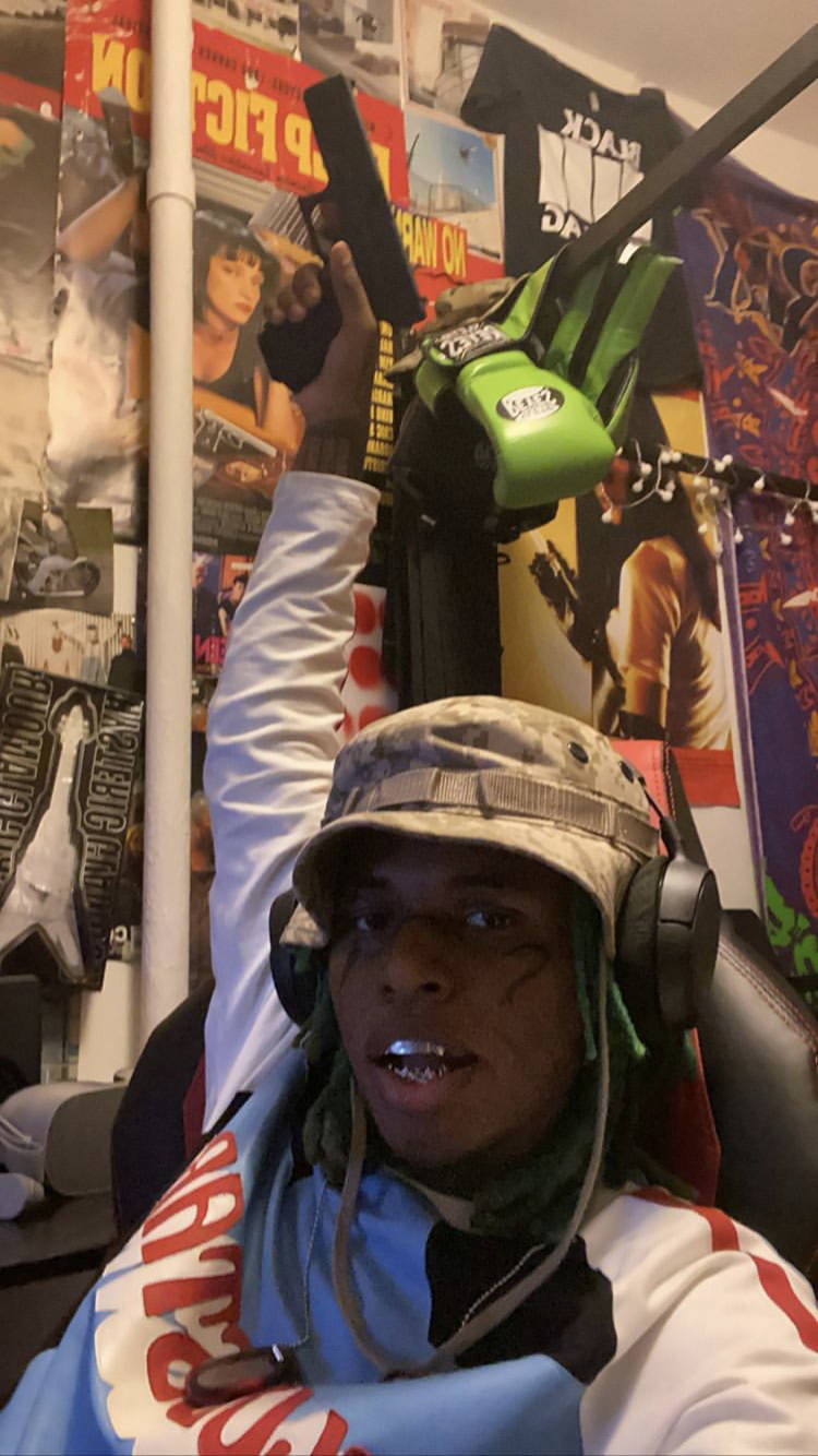 Zillakami Pointing A Gun Above Background